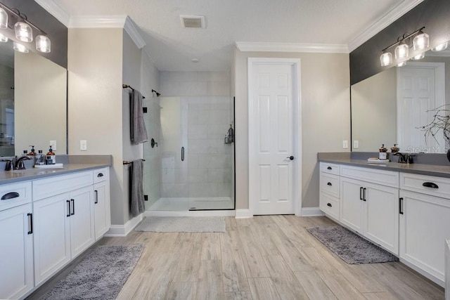 15787 Tangerine Dream Ct, Winter Garden, FL 34787 - bathroom with a shower stall, two vanities, wood finished floors, and crown molding