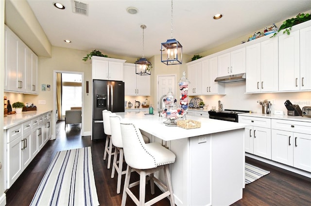 436 Skyview Pl, Chuluota, FL 32766 - kitchen with stainless steel fridge with ice dispenser, under cabinet range hood, recessed lighting, light countertops, and a kitchen bar