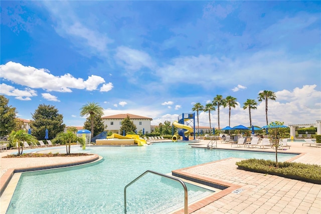 561 Gunston Ct, Davenport, FL 33837 - community pool with a water slide and a patio area