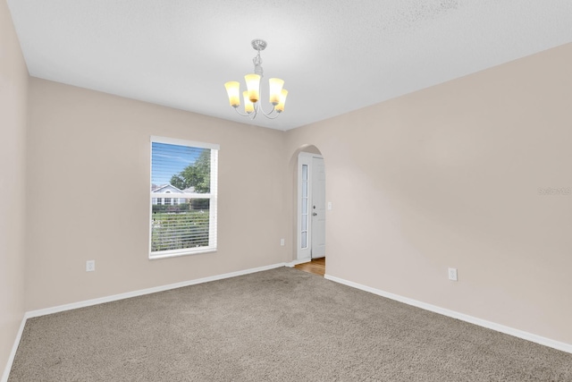 16053 Wilkinson Dr, Clermont, FL 34714 - empty room with a chandelier, arched walkways, and carpet floors