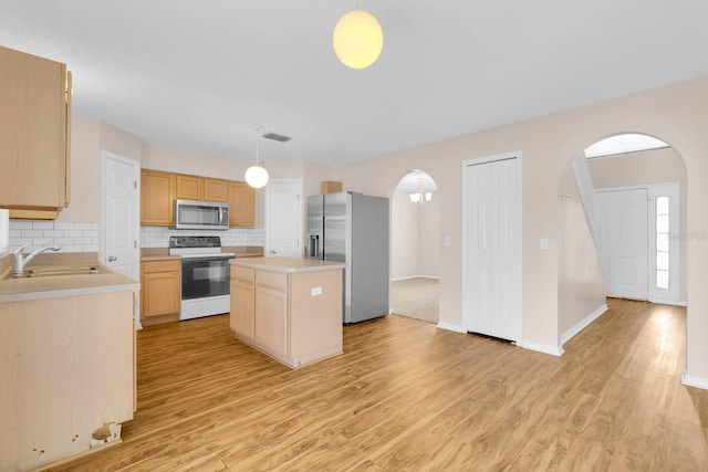 16053 Wilkinson Dr, Clermont, FL 34714 - kitchen featuring stainless steel appliances, arched walkways, light wood finished floors, and light countertops