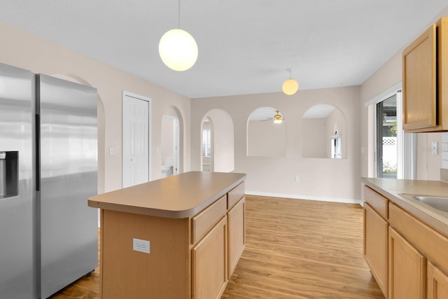 16053 Wilkinson Dr, Clermont, FL 34714 - kitchen with stainless steel refrigerator with ice dispenser, light wood-style floors, arched walkways, and a center island