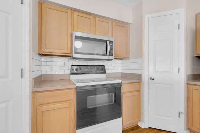 16053 Wilkinson Dr, Clermont, FL 34714 - kitchen with stainless steel microwave, electric stove, and light brown cabinetry