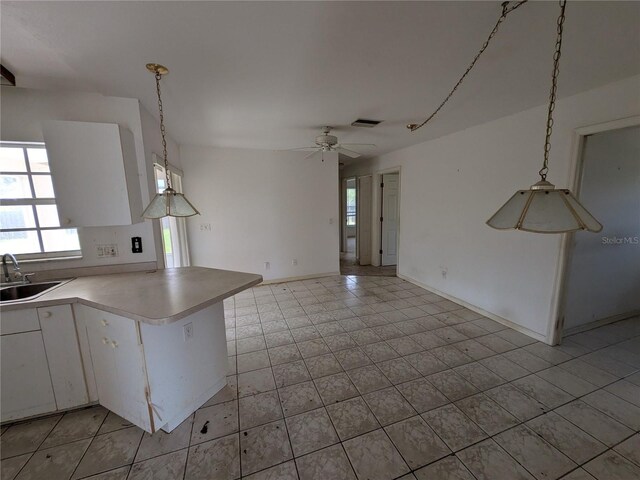 1140 Belmar Ave, Port Charlotte, FL 33948 - kitchen featuring healthy amount of natural light, white cabinetry, a peninsula, and ceiling fan