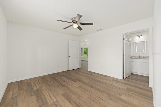 13031 NE 7th Loop, Silver Springs, FL 34488 - unfurnished bedroom with light wood finished floors, ensuite bathroom, and ceiling fan