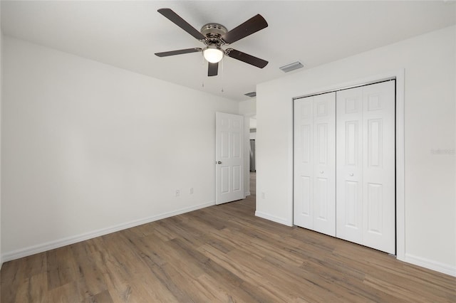 13031 NE 7th Loop, Silver Springs, FL 34488 - unfurnished bedroom featuring wood finished floors, a closet, and a ceiling fan