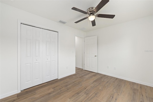 13031 NE 7th Loop, Silver Springs, FL 34488 - unfurnished bedroom featuring wood finished floors, a closet, and a ceiling fan