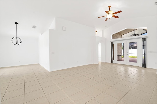 9003 Pecky Cypress Way, Orlando, FL 32836 - spare room with a ceiling fan, light tile patterned floors, arched walkways, high vaulted ceiling, and french doors