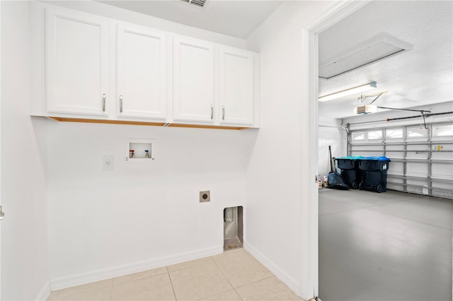 9003 Pecky Cypress Way, Orlando, FL 32836 - washroom featuring hookup for an electric dryer, hookup for a washing machine, cabinet space, a garage, and light tile patterned flooring