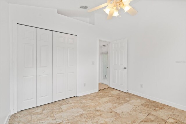 9003 Pecky Cypress Way, Orlando, FL 32836 - unfurnished bedroom featuring a closet, ceiling fan, and stone finish floors