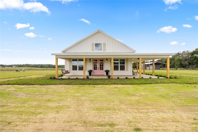 2212 SW 210th Ave, Dunnellon, FL 34431 - view of front of home featuring french doors, board and batten siding, a front lawn, and a patio area