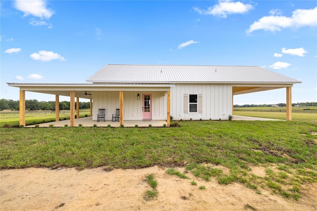 2212 SW 210th Ave, Dunnellon, FL 34431 - view of front of house with board and batten siding, a front lawn, an attached carport, and a patio