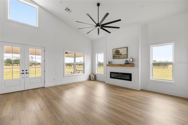 2212 SW 210th Ave, Dunnellon, FL 34431 - unfurnished living room with a glass covered fireplace, high vaulted ceiling, light wood-style flooring, french doors, and a ceiling fan
