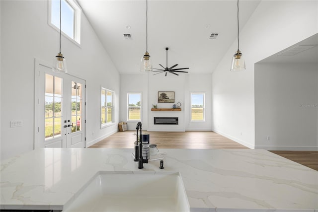 2212 SW 210th Ave, Dunnellon, FL 34431 - unfurnished living room featuring healthy amount of natural light, high vaulted ceiling, french doors, light wood-style flooring, and a glass covered fireplace