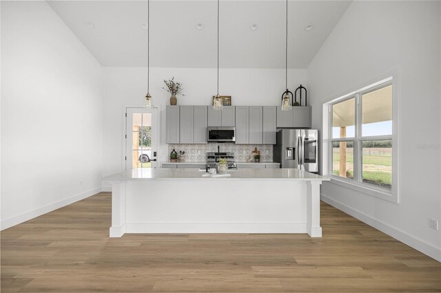 2212 SW 210th Ave, Dunnellon, FL 34431 - kitchen featuring stainless steel appliances, high vaulted ceiling, gray cabinetry, light countertops, and backsplash