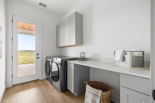 2212 SW 210th Ave, Dunnellon, FL 34431 - washroom with cabinet space, washer and clothes dryer, and light wood-style floors