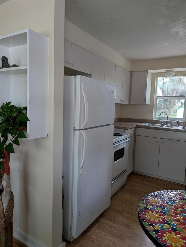 417 Shore Rd, Nokomis, FL 34275 - kitchen featuring white appliances, wood finished floors, and white cabinetry