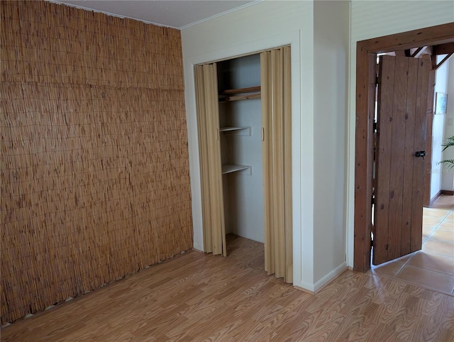 417 Shore Rd, Nokomis, FL 34275 - unfurnished bedroom featuring a closet, light wood-type flooring, and crown molding
