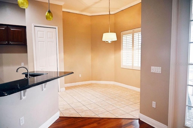 3504 Shorewood Dr, Kissimmee, FL 34746 - kitchen featuring ornamental molding, pendant lighting, dark countertops, and light wood-type flooring