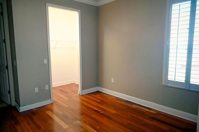 3504 Shorewood Dr, Kissimmee, FL 34746 - unfurnished bedroom with a spacious closet, dark wood-style flooring, crown molding, and a closet