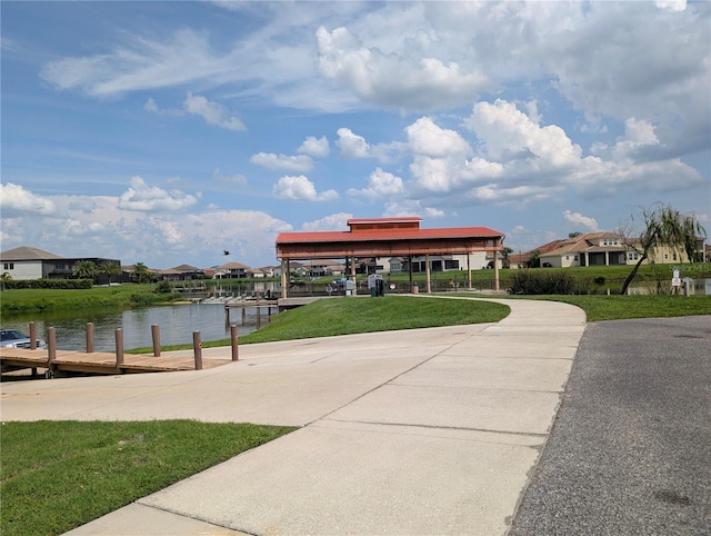 3504 Shorewood Dr, Kissimmee, FL 34746 - view of property's community featuring a boat dock, driveway, a water view, a yard, and a carport