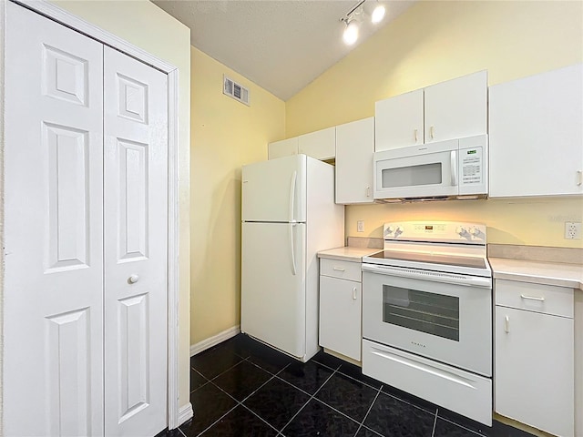 1751 Chatham Cir, Apopka, FL 32703 - kitchen with white appliances, vaulted ceiling, dark tile patterned floors, light countertops, and white cabinets