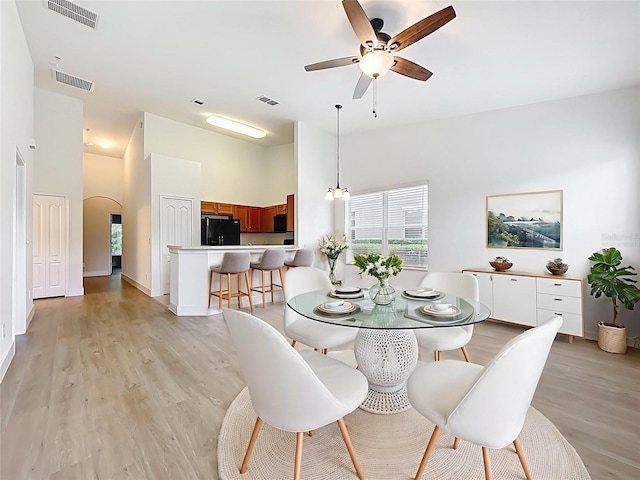2092 Switch Grass Cir, Ocoee, FL 34761 - dining room with ceiling fan, light wood-style floors, a high ceiling, and arched walkways