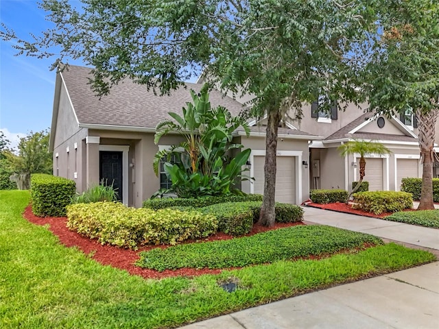 2092 Switch Grass Cir, Ocoee, FL 34761 - obstructed view of property featuring stucco siding, a garage, roof with shingles, and driveway