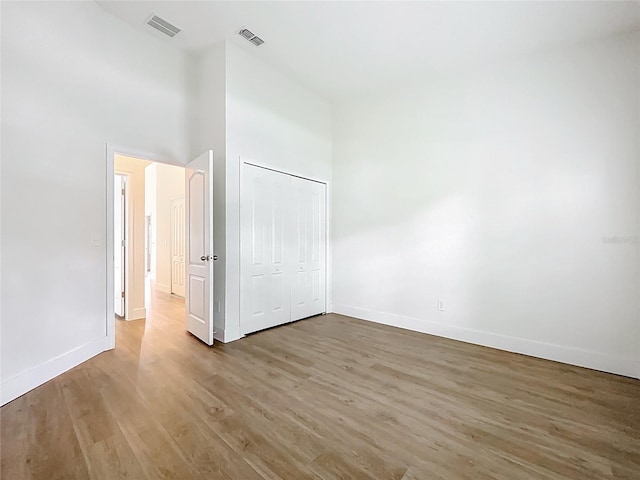 2092 Switch Grass Cir, Ocoee, FL 34761 - unfurnished bedroom featuring light wood-style flooring, a towering ceiling, and a closet