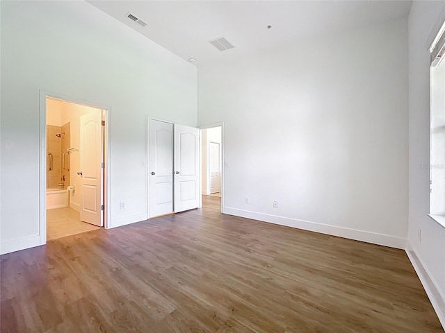 2092 Switch Grass Cir, Ocoee, FL 34761 - unfurnished bedroom featuring a towering ceiling, wood finished floors, and ensuite bath