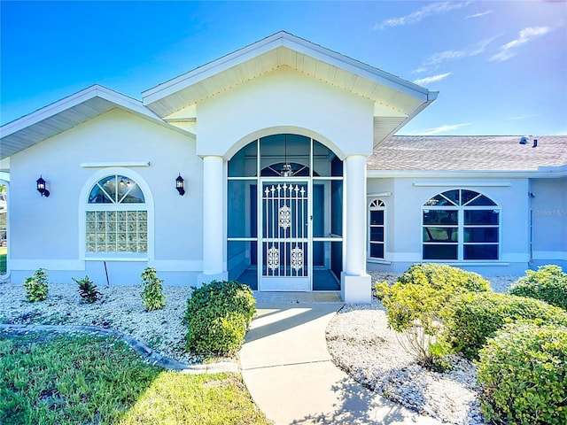 142 Broadmoor Ln, Rotonda West, FL 33947 - view of exterior entry featuring stucco siding and roof with shingles