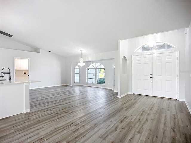 142 Broadmoor Ln, Rotonda West, FL 33947 - entryway with wood finished floors, a chandelier, and vaulted ceiling
