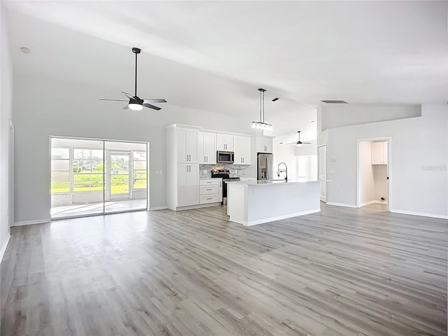 142 Broadmoor Ln, Rotonda West, FL 33947 - unfurnished living room with ceiling fan, high vaulted ceiling, and light wood finished floors