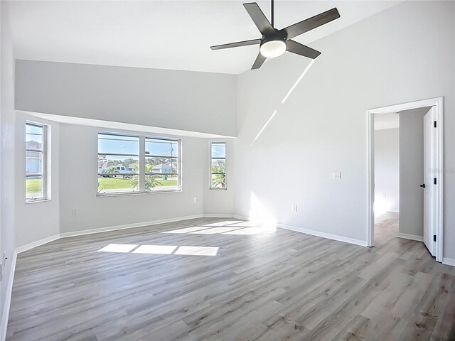 142 Broadmoor Ln, Rotonda West, FL 33947 - empty room with high vaulted ceiling, plenty of natural light, light wood-style flooring, and a ceiling fan