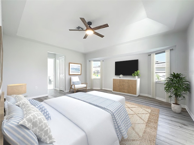 142 Broadmoor Ln, Rotonda West, FL 33947 - bedroom with a raised ceiling, multiple windows, wood finished floors, and a ceiling fan