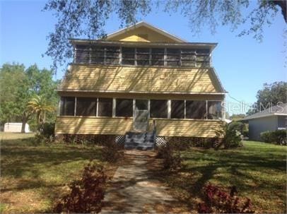 430 W Minnehaha Ave, Clermont, FL 34711 - view of front of house featuring a sunroom and a front lawn