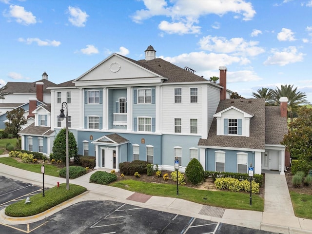 7615 Heritage Crossing Way Unit 201, Reunion, FL 34747 - view of front facade featuring a shingled roof, uncovered parking, and stucco siding