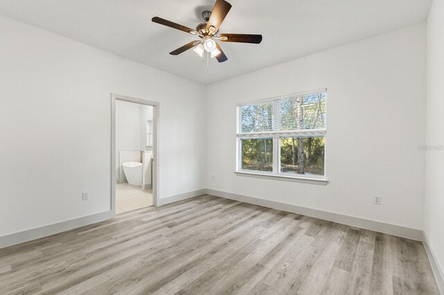 2451 W Menores Dr, Citrus Springs, FL 34434 - unfurnished bedroom featuring light wood finished floors, connected bathroom, and a ceiling fan