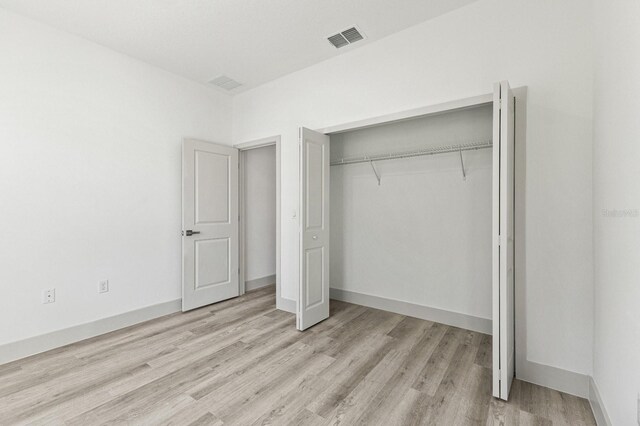 2451 W Menores Dr, Citrus Springs, FL 34434 - unfurnished bedroom featuring wood finished floors and a closet