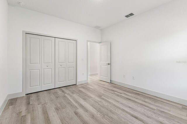 2451 W Menores Dr, Citrus Springs, FL 34434 - unfurnished bedroom with wood finished floors and a closet