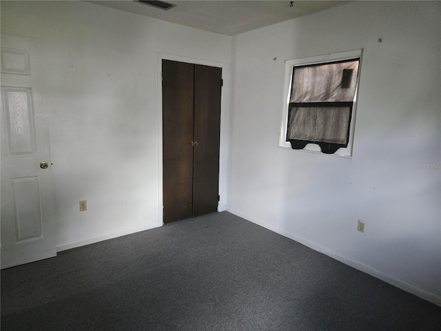 2308 18th St E, Bradenton, FL 34208 - unfurnished bedroom with baseboards and dark colored carpet