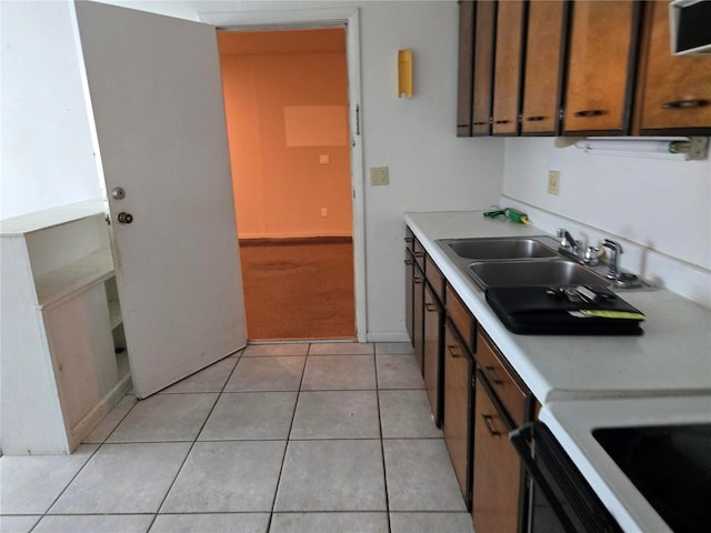 2308 18th St E, Bradenton, FL 34208 - kitchen with light countertops, light tile patterned flooring, brown cabinetry, and light carpet