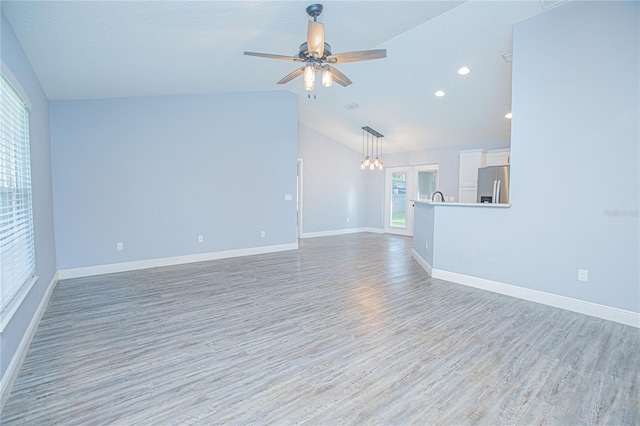 4911 NE 7th St, Ocala, FL 34470 - unfurnished living room featuring light wood-style flooring, lofted ceiling, ceiling fan, a chandelier, and recessed lighting