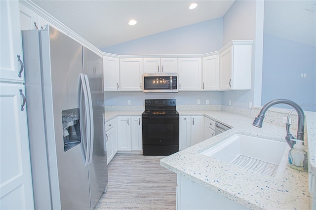 4911 NE 7th St, Ocala, FL 34470 - kitchen featuring appliances with stainless steel finishes, vaulted ceiling, light wood-type flooring, white cabinetry, and recessed lighting