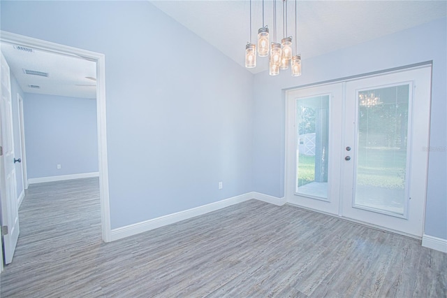 4911 NE 7th St, Ocala, FL 34470 - unfurnished room featuring wood finished floors, french doors, and a chandelier