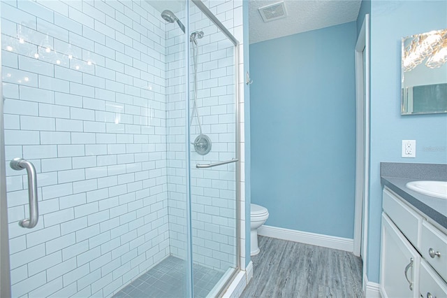 4911 NE 7th St, Ocala, FL 34470 - bathroom with vanity, a stall shower, a textured ceiling, and wood finished floors