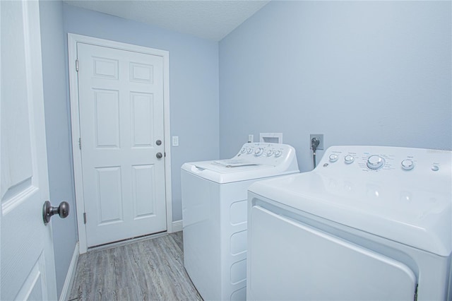 4911 NE 7th St, Ocala, FL 34470 - washroom with washing machine and dryer, light wood-type flooring, and a textured ceiling