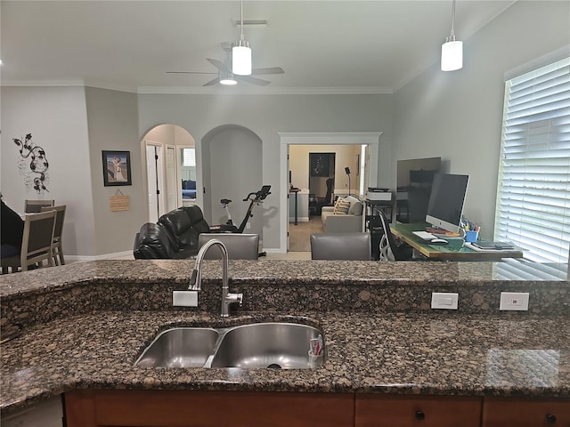 1884 Coconut Palm Cir, North Port, FL 34288 - kitchen with arched walkways, open floor plan, a ceiling fan, dark stone countertops, and ornamental molding