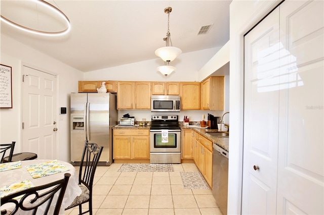 3415 Celena Cir, Saint Cloud, FL 34769 - kitchen featuring appliances with stainless steel finishes, light brown cabinetry, lofted ceiling, light tile patterned flooring, and decorative light fixtures