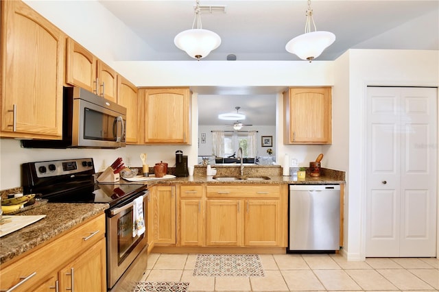 3415 Celena Cir, Saint Cloud, FL 34769 - kitchen with appliances with stainless steel finishes, light brown cabinetry, light tile patterned floors, and dark stone counters